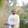 A man in traditional attire stands outdoors in Kasur, Punjab, Pakistan, embracing cultural fashion.